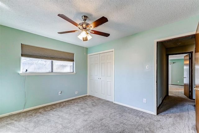 unfurnished bedroom with ceiling fan, light colored carpet, a closet, and a textured ceiling