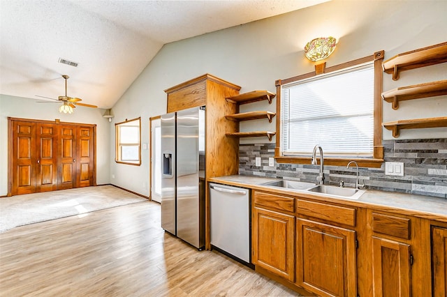 kitchen featuring appliances with stainless steel finishes, sink, lofted ceiling, and plenty of natural light