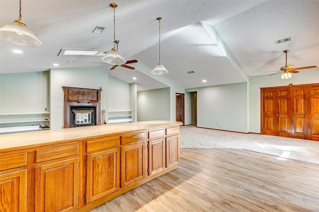 kitchen featuring hanging light fixtures, lofted ceiling, and ceiling fan