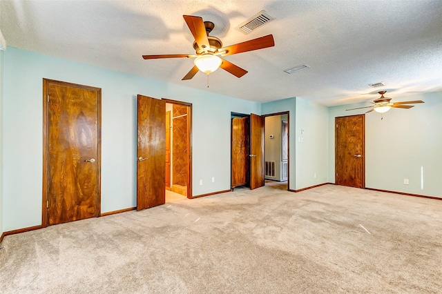 unfurnished bedroom featuring light carpet, ceiling fan, and a textured ceiling