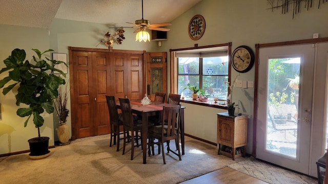 dining area featuring light carpet, ceiling fan, high vaulted ceiling, and a textured ceiling