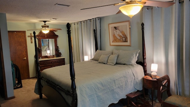 bedroom with ceiling fan, light carpet, and a textured ceiling