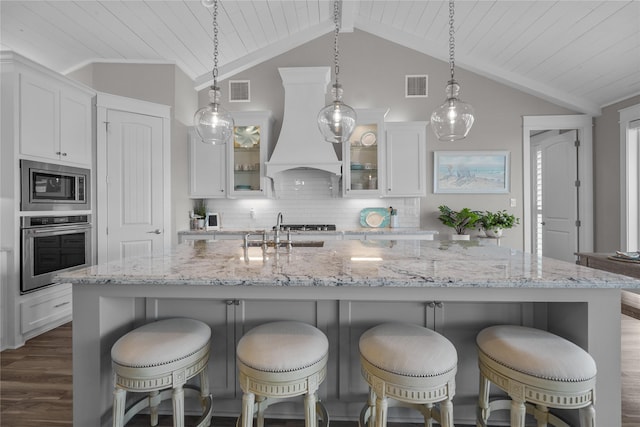 kitchen featuring decorative light fixtures, white cabinetry, sink, stainless steel appliances, and custom range hood