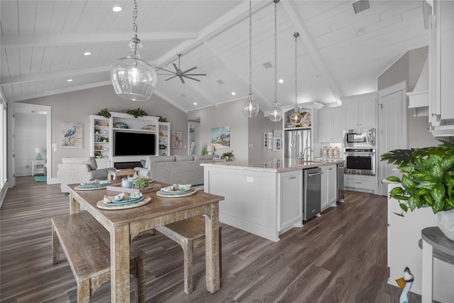 kitchen with hanging light fixtures, an island with sink, appliances with stainless steel finishes, and white cabinets