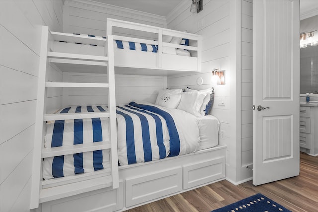 bedroom featuring hardwood / wood-style flooring and wood walls