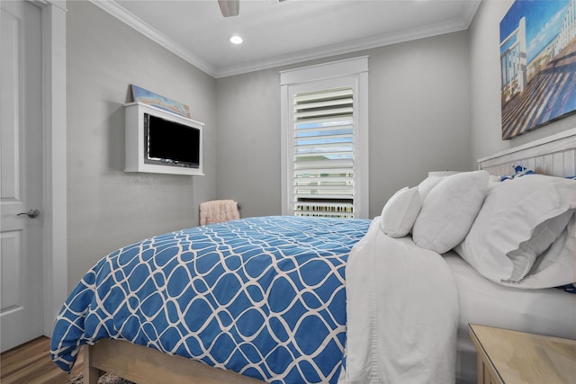 bedroom with crown molding, ceiling fan, and hardwood / wood-style floors