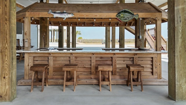 bar featuring concrete flooring and a healthy amount of sunlight