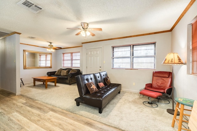 living room featuring crown molding, a textured ceiling, and light wood-type flooring