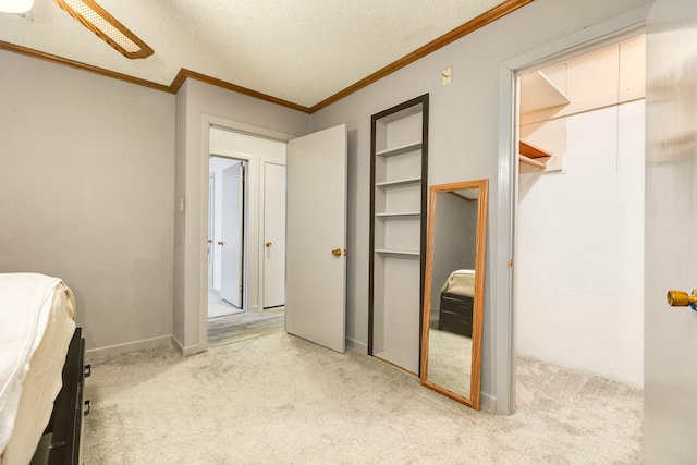 unfurnished bedroom featuring ceiling fan, ornamental molding, light carpet, and a textured ceiling