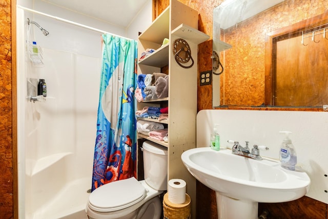 bathroom featuring sink, curtained shower, and toilet