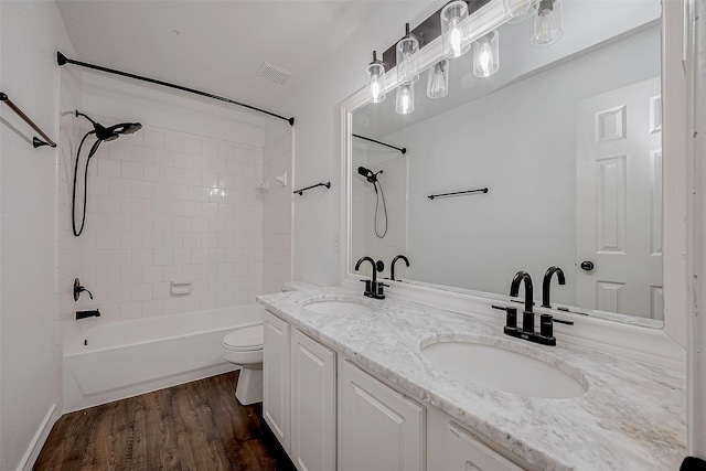 full bathroom with vanity, toilet, tiled shower / bath combo, and hardwood / wood-style floors