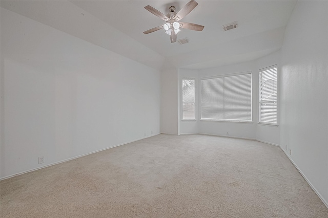 empty room featuring ceiling fan, light carpet, and a wealth of natural light