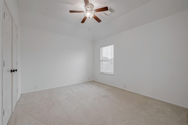 spare room featuring light carpet and ceiling fan