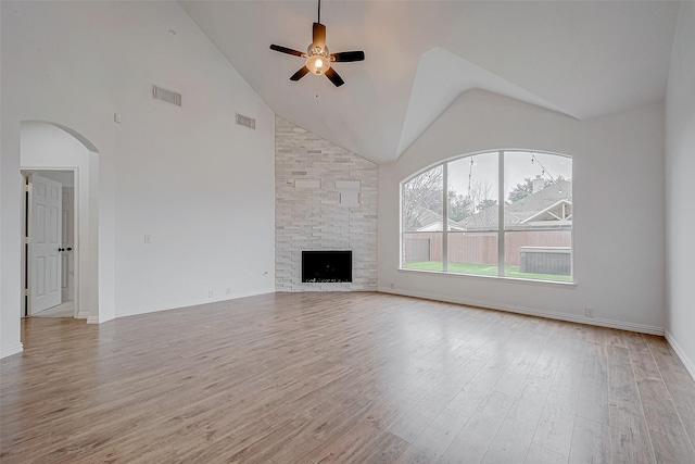 unfurnished living room with high vaulted ceiling, a fireplace, ceiling fan, and light hardwood / wood-style flooring