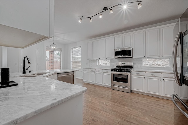 kitchen featuring white cabinetry, sink, pendant lighting, and stainless steel appliances