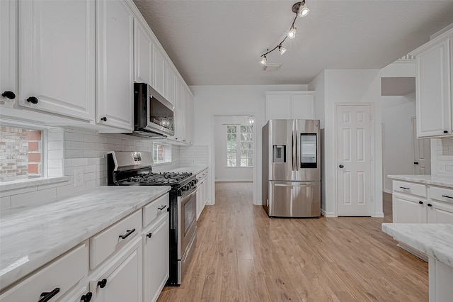 kitchen featuring white cabinetry, light stone countertops, and stainless steel appliances