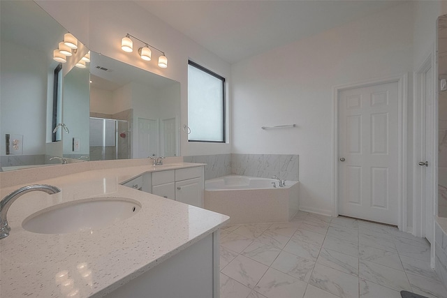 bathroom with vanity and shower with separate bathtub