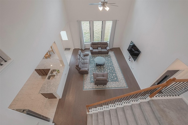 living room with ceiling fan and a high ceiling