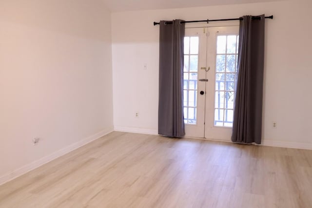 unfurnished room with french doors and light hardwood / wood-style flooring