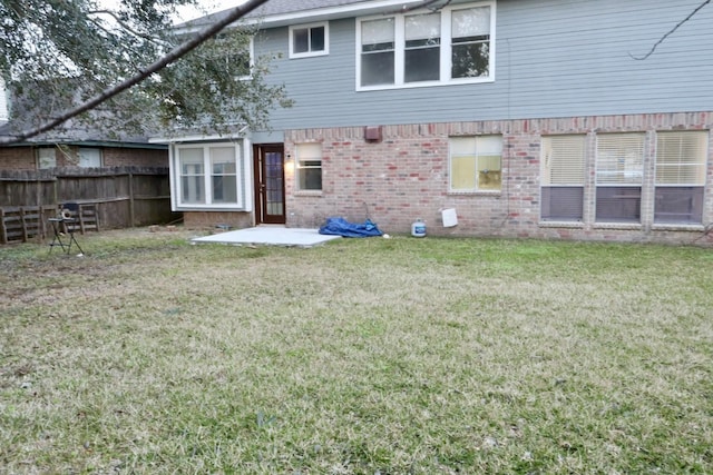 back of property featuring a patio area and a lawn