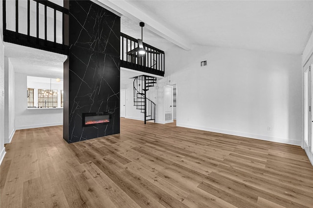 unfurnished living room with beam ceiling, a chandelier, high vaulted ceiling, a fireplace, and hardwood / wood-style floors