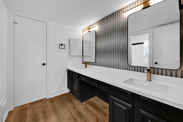 bathroom with hardwood / wood-style flooring, vanity, and a textured ceiling