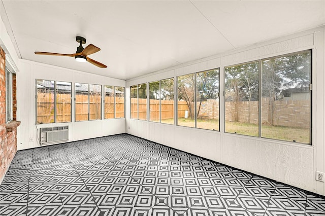 unfurnished sunroom featuring ceiling fan, plenty of natural light, and an AC wall unit