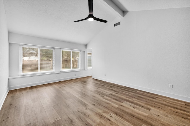 spare room with hardwood / wood-style flooring, vaulted ceiling with beams, a textured ceiling, and ceiling fan