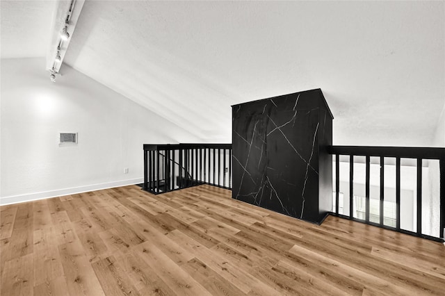 interior space with lofted ceiling with beams and light hardwood / wood-style floors