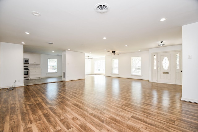 unfurnished living room featuring ceiling fan and light hardwood / wood-style floors