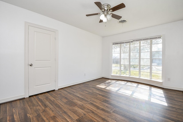 empty room with ceiling fan and dark hardwood / wood-style floors