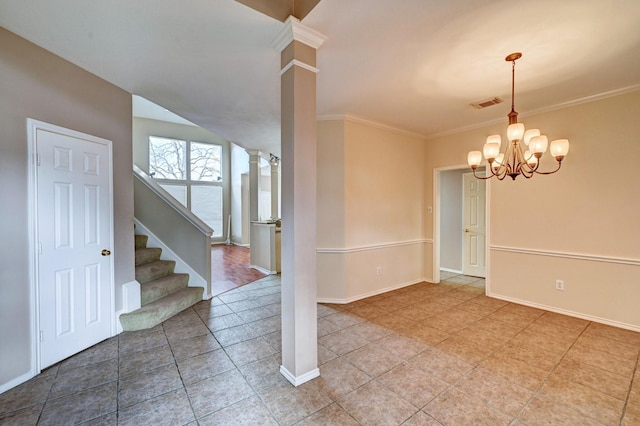 spare room with ornate columns, crown molding, tile patterned floors, and a chandelier