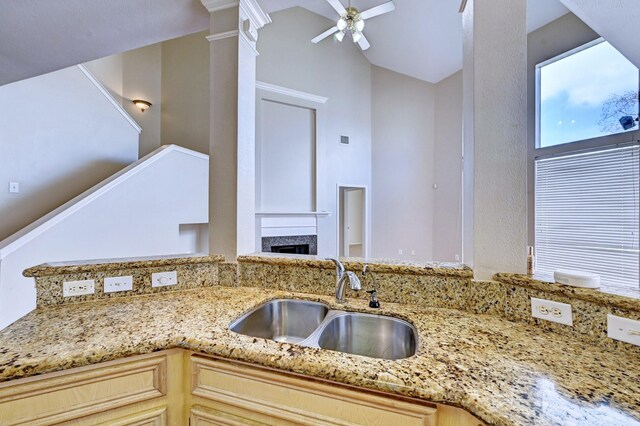 12726 Silverglen Estates Dr, Houston, TX 77014 - kitchen with light stone countertops, a fireplace, a sink, and a ceiling fan