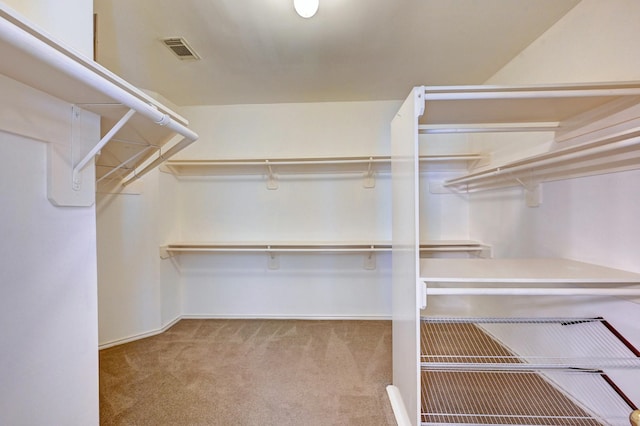 walk in closet featuring light carpet