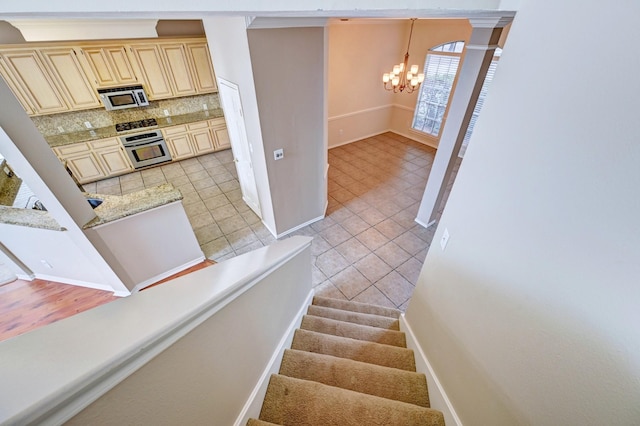 12726 Silverglen Estates Dr, Houston, TX 77014 - staircase featuring tile patterned floors, baseboards, and an inviting chandelier