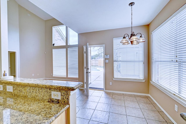 doorway featuring light tile patterned flooring and a chandelier