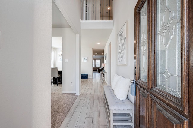 foyer featuring light wood-style flooring, baseboards, and recessed lighting