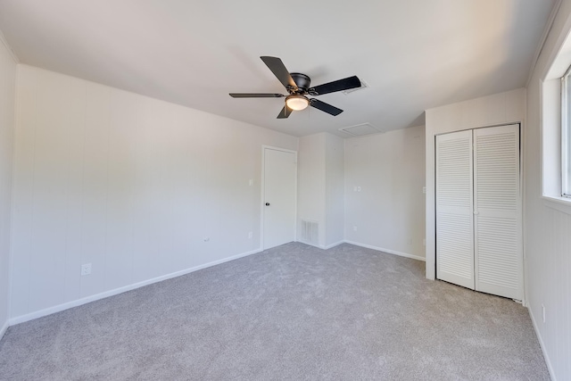 unfurnished bedroom featuring ceiling fan, light colored carpet, and a closet