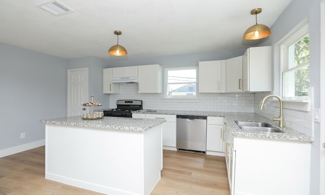 kitchen featuring hanging light fixtures, stainless steel dishwasher, gas range oven, and a center island