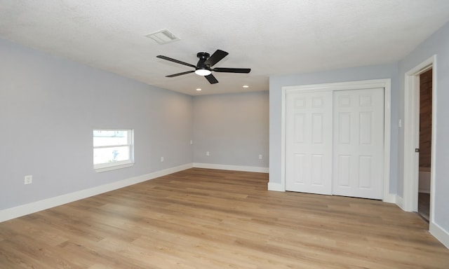 unfurnished bedroom featuring ceiling fan, light hardwood / wood-style floors, a closet, and a textured ceiling