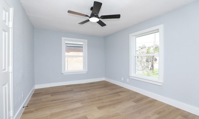 unfurnished room with ceiling fan, a healthy amount of sunlight, light hardwood / wood-style floors, and a textured ceiling