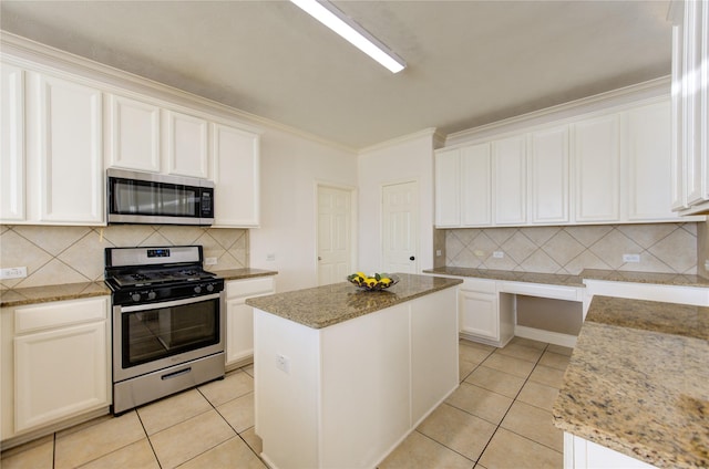 kitchen with light stone countertops, light tile patterned floors, stainless steel appliances, and a center island