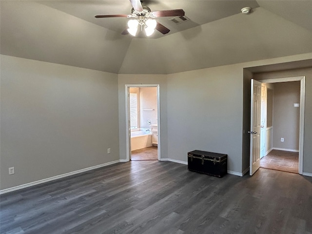 unfurnished bedroom with vaulted ceiling, dark hardwood / wood-style floors, ceiling fan, and ensuite bathroom