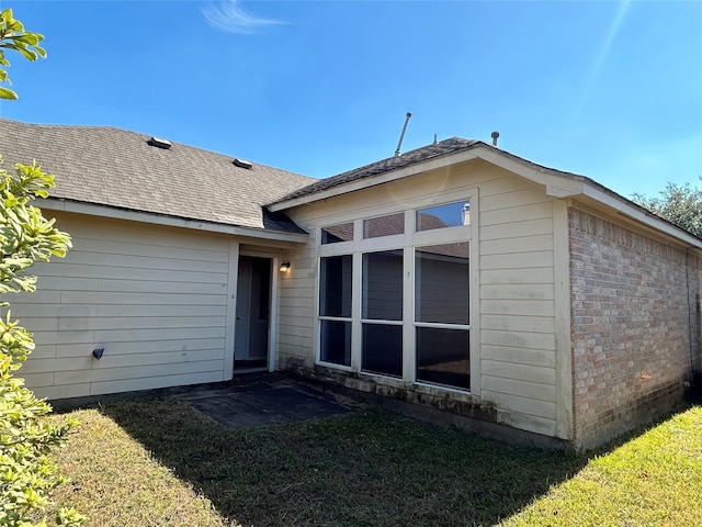 rear view of house featuring a lawn