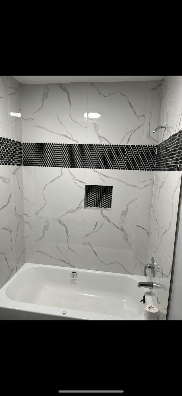 bathroom with tiled shower / bath combo