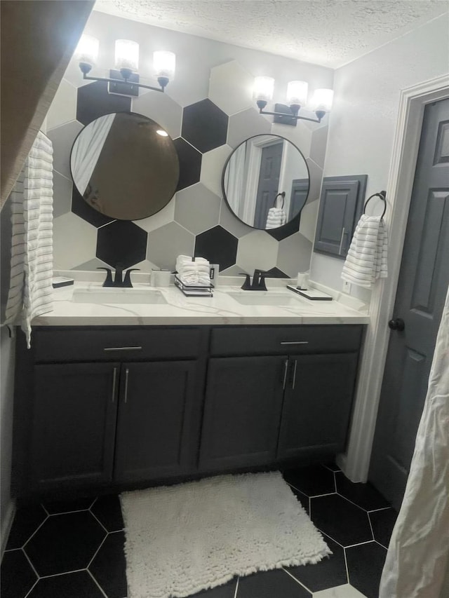 bathroom featuring tasteful backsplash, vanity, tile patterned floors, and a textured ceiling