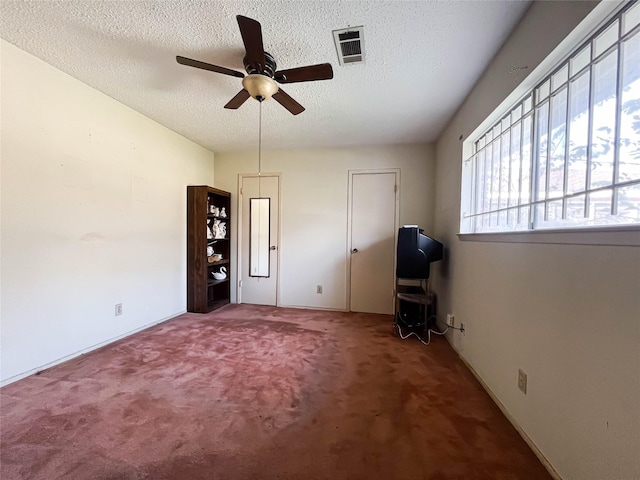 interior space featuring ceiling fan and a textured ceiling