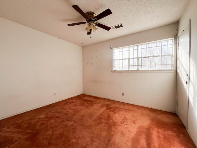 spare room featuring ceiling fan, carpet floors, and a textured ceiling