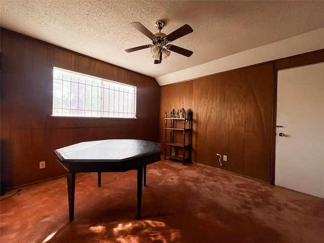 misc room with carpet, wooden walls, and a textured ceiling