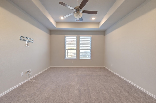 spare room with carpet floors, a raised ceiling, and ceiling fan